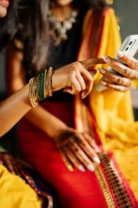 Indian women in sarees playing on a mobile phone